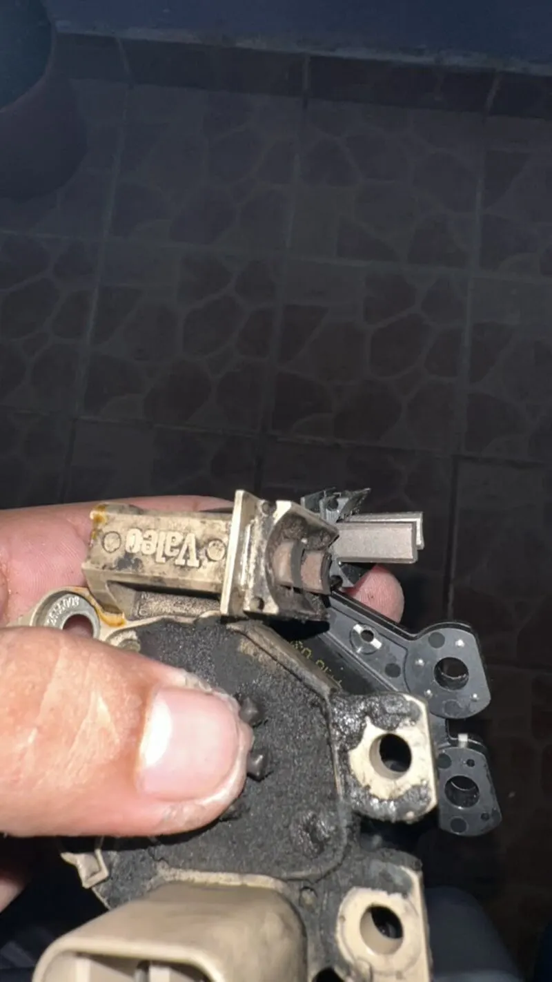 Regulador de alternador dañado junto al regulador nuevo, antes de la reparación